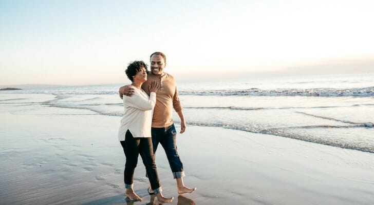 A retired couple takes a walk on a beach. High-net-worth individuals use different retirement strategies to protect their assets.