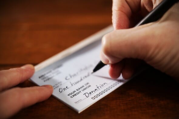 close up view of hand writing a donation check picture id465426619