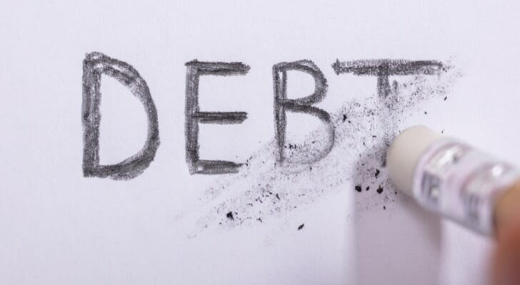 The word "DEBT" being partially erased