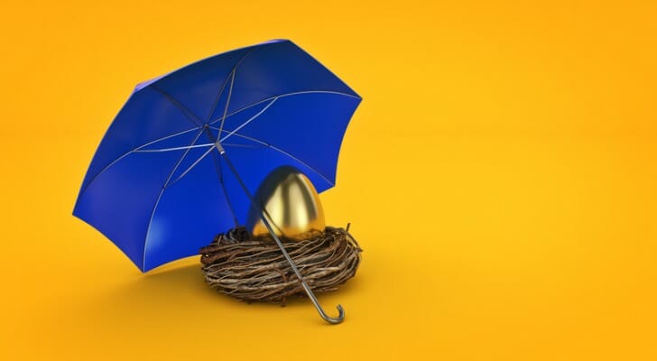 A golden egg, resting in a nest with an umbrella over it