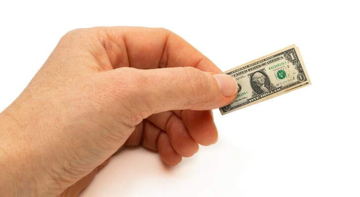 Hand holding a shrunken dollar bill