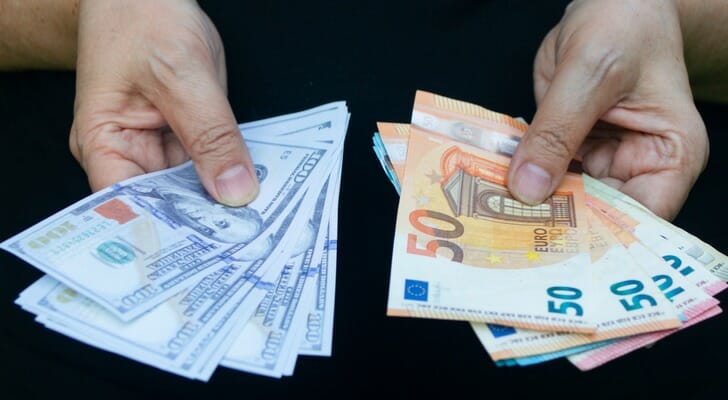 Man holding U.S. dollars and euro bills