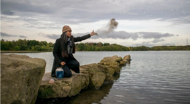 Woman scattering ashes from a cremated love one into the sea