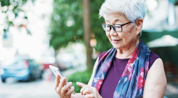Elderly woman using her mobile trading app