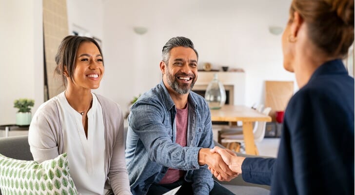 A couple meets with their financial advisor. A recent survey found that those with more than $1.2 million in household assets report significantly higher levels of happiness when working with a financial advisor compared to those without an advisor. 