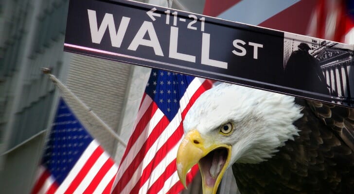 A photo of a bald eagle, two Amercan flags and a street sign that says Wall Street