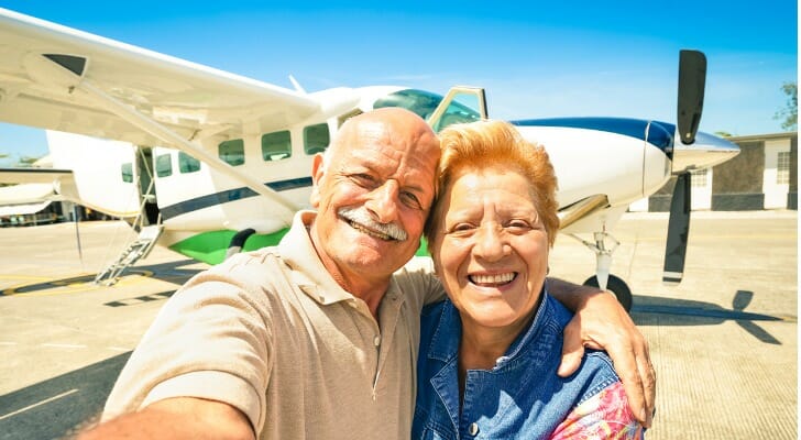 Retired couple in front of their plane