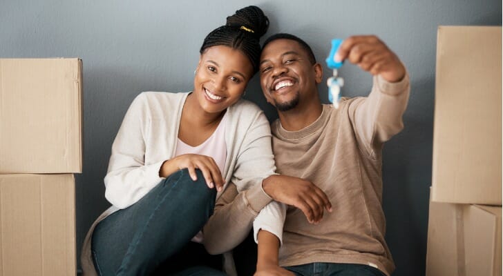 Image shows two new homeowners showing off the keys to their new place. SmartAsset set out to determine which states are best for homeowners in 2021.