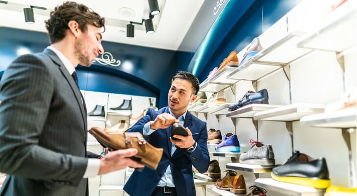 Man in a shoe store, talking to a sales person