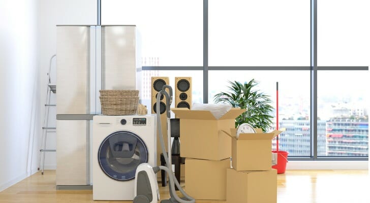 Image shows boxes and appliances stacked in the middle of an otherwise empty apartment on moving day. SmartAsset analyzed IRS data to complete this year's study on where rich millennials are moving.