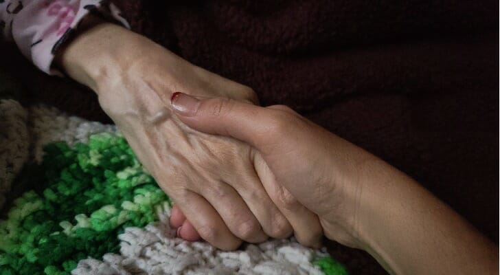 Care giver holding hands with an elderly client