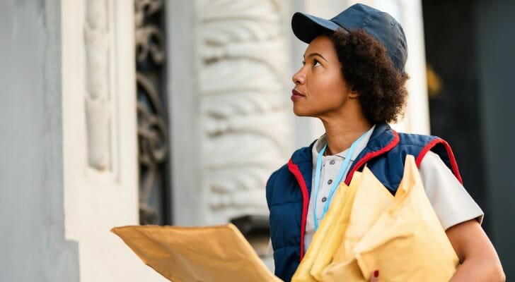 Image shows a woman who works as a courier holding several large envelopes at a delivery address. SmartAsset used BLS data to conduct this year's study on the fastest-growing jobs for women.
