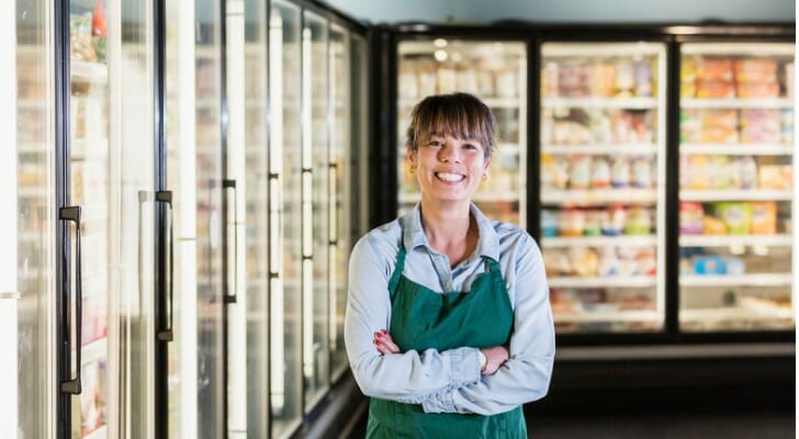 Grocery store employee standing in the freezed food section