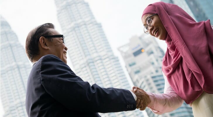 Malaysian businessman shakes hands with his financial advisor