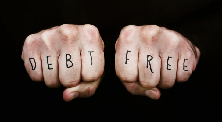 "Debt Free" written on a man's fingers
