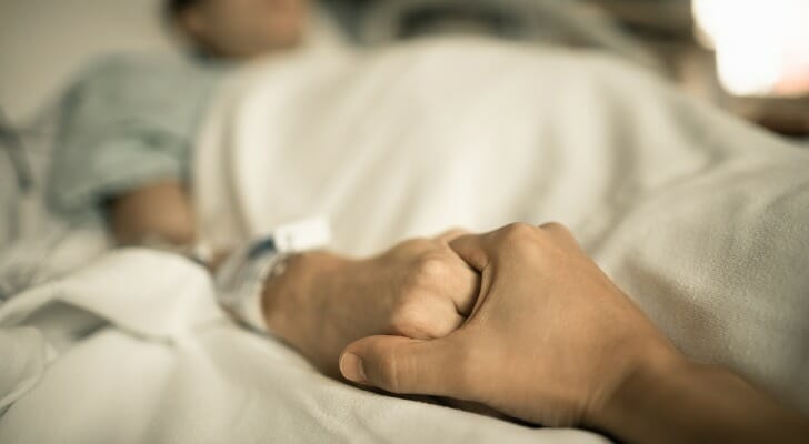 Man holds female hospital patient's hand