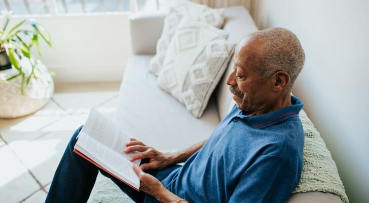 A man reads a book on retirement planning. SmartAsset put together a roundup of the best retirement planning books to read in 2022. 