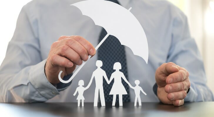 Man holding an umbrella over his family