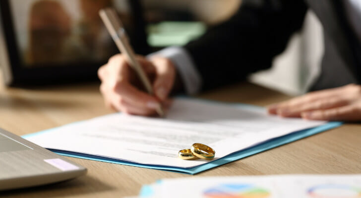 Image shows a person signing divorce documents. 2021 SmartAsset Study: Where Divorces Are Becoming More Common