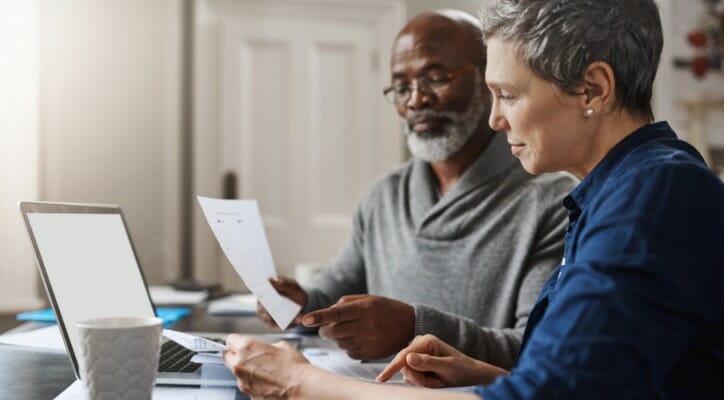 A couple looks over their investment portfolio. T. Rowe Price recently published its year-end tips for retirement savers. 