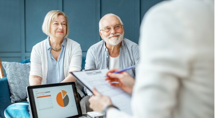 A retired couple meets with their financial advisor. J.P. Morgan has developed precise income replacement targets based on a retiree's pre-retirement income. 