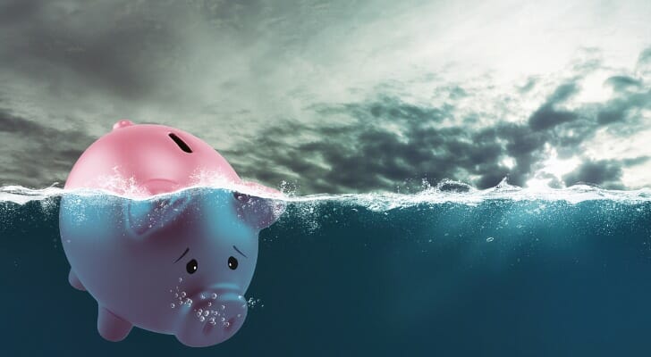 Picture of a piggy bank sinking beneath the surface of the sea.