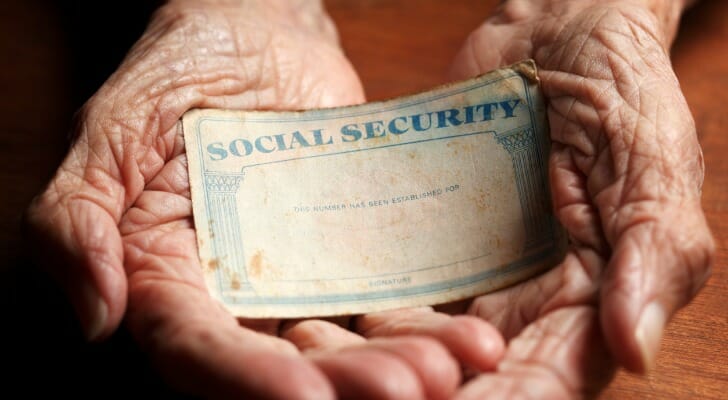 Elderly person's hands holding a Social Security card