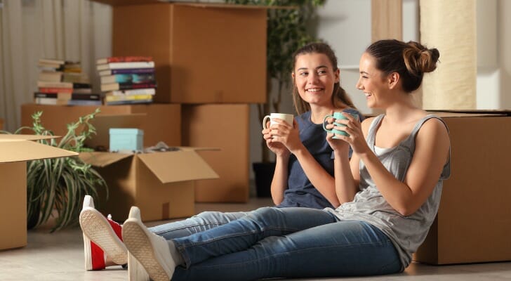 Two roommates sit in their new apartment and enjoy a cup of coffee on moving day. SmartAsset analyzed rental data to conduct its latest study on what a roommate saves you in 50 U.S. cities.
