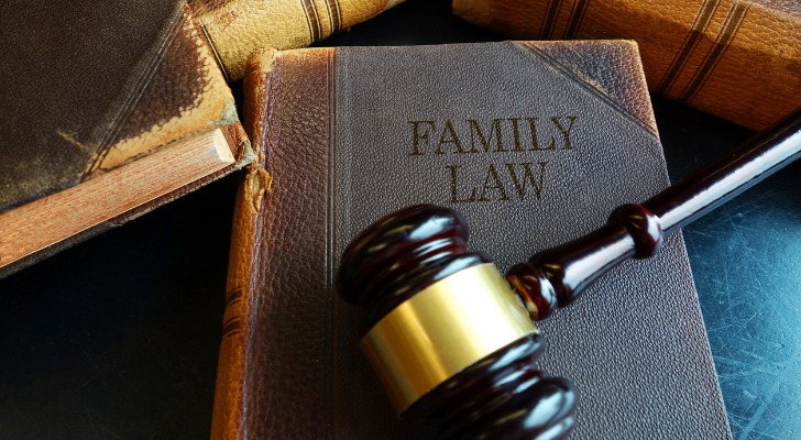 Image shows a gavel on top of a large book titled "Family Law." SmartAsset takes a closer look at the differences between custody and guardianship.