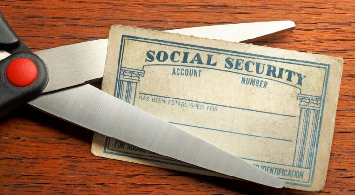 Scissors about to cut a Social Security card