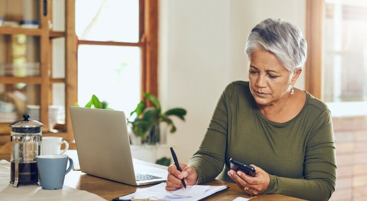 A retiree calculates her required minimum distribution (RMD). The IRS has updated its Uniform Lifetime Table, lowering the size of RMDs in 2022. 