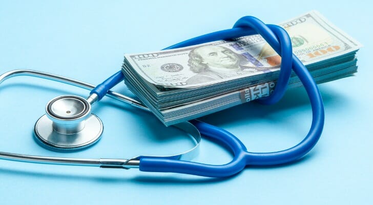 A stethoscope and a stack of $100 bills