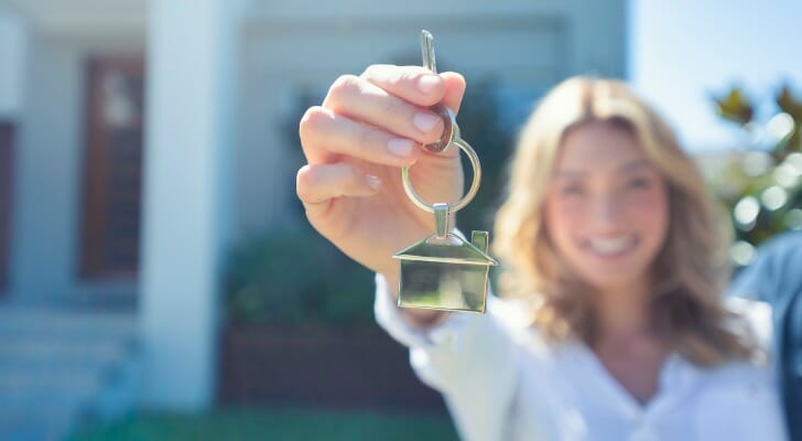 一个新房主拿着钥匙。伟德ios appSmartAsset分析了各种指标的数据，以确定购买住房最便宜的州。
