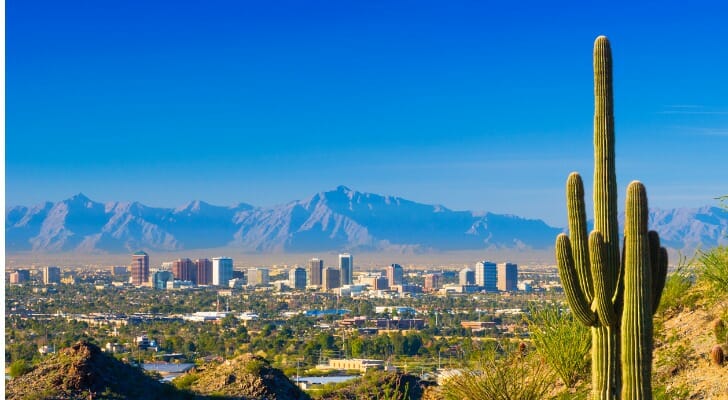 Phoenix skyline with mountains in the background and a big cactus in the foreground