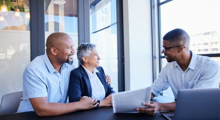 This image shows an advisor discussing paperwork with clients